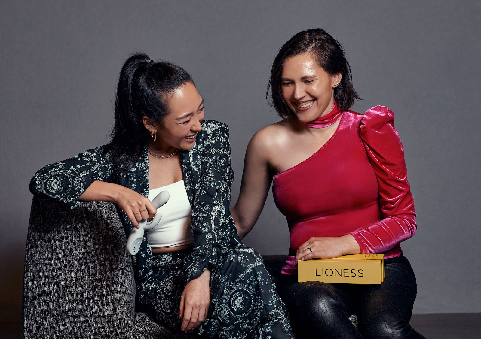 Lioness Co-founders Anna and Liz holding Lioness and box while sitting on couch
